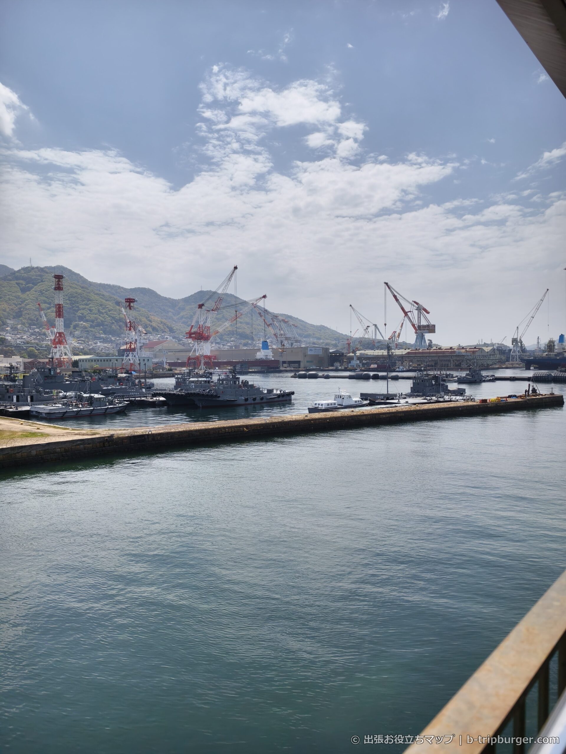 呉港の眺め。海上自衛隊の艦船と造船所のクレーン群